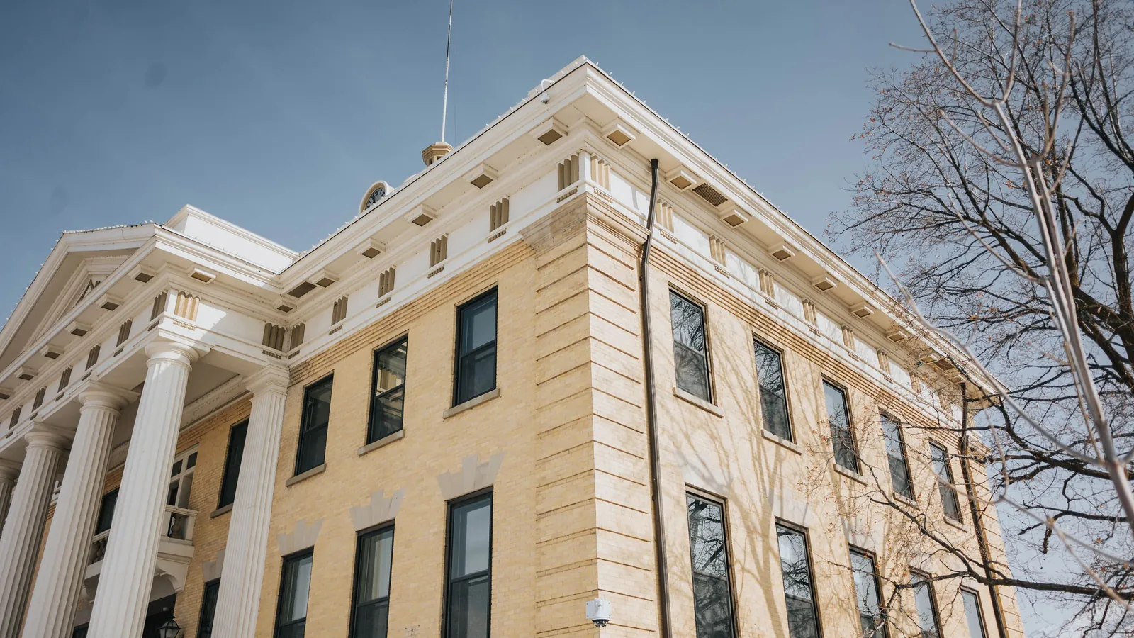 A neoclassical county courthouse with white columns photographed from below against a clear blue sky, standing in for the federal appeals ruling that AI shopping agents acting for a person may reach a retailer's site.